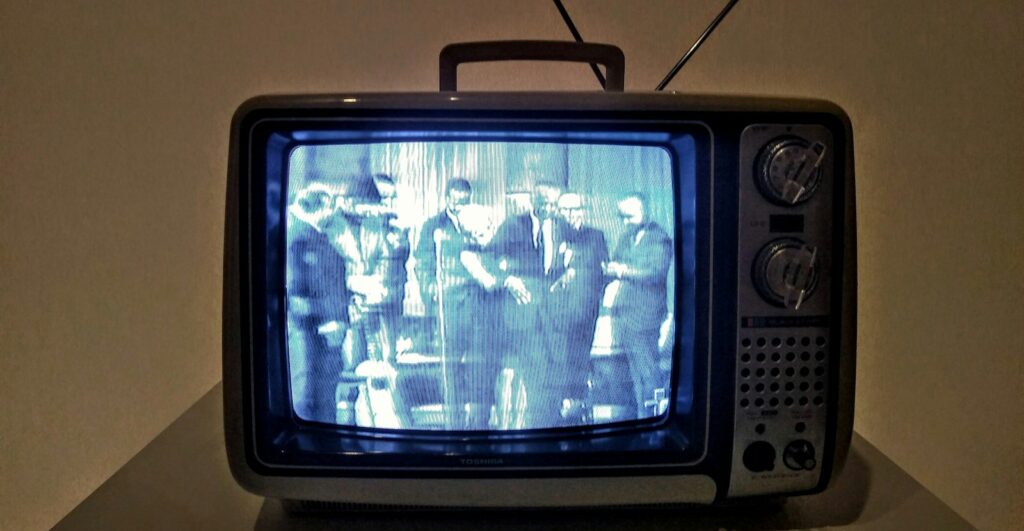black crt tv turned on on white table